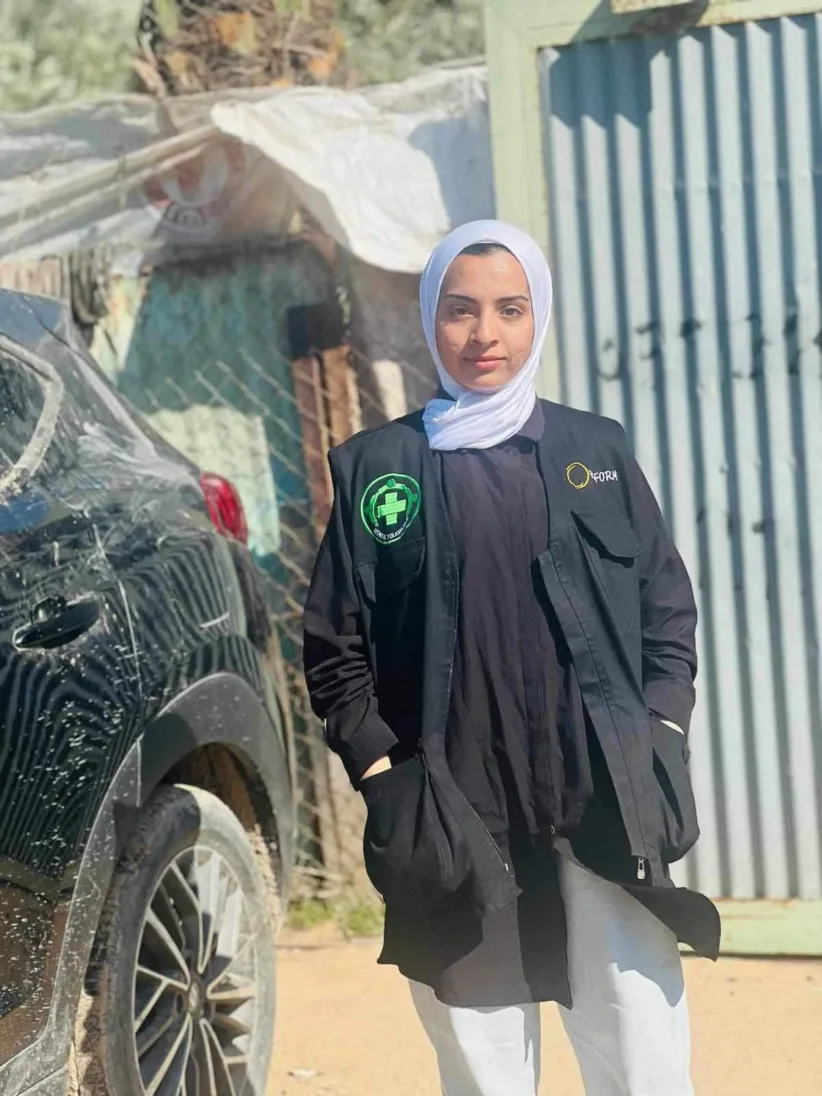 Bayan Hazem Musleh står ved en bil og ser i kameraet